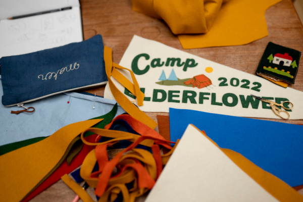 Pieces of felt and materials and a pennant flag on a makers table.