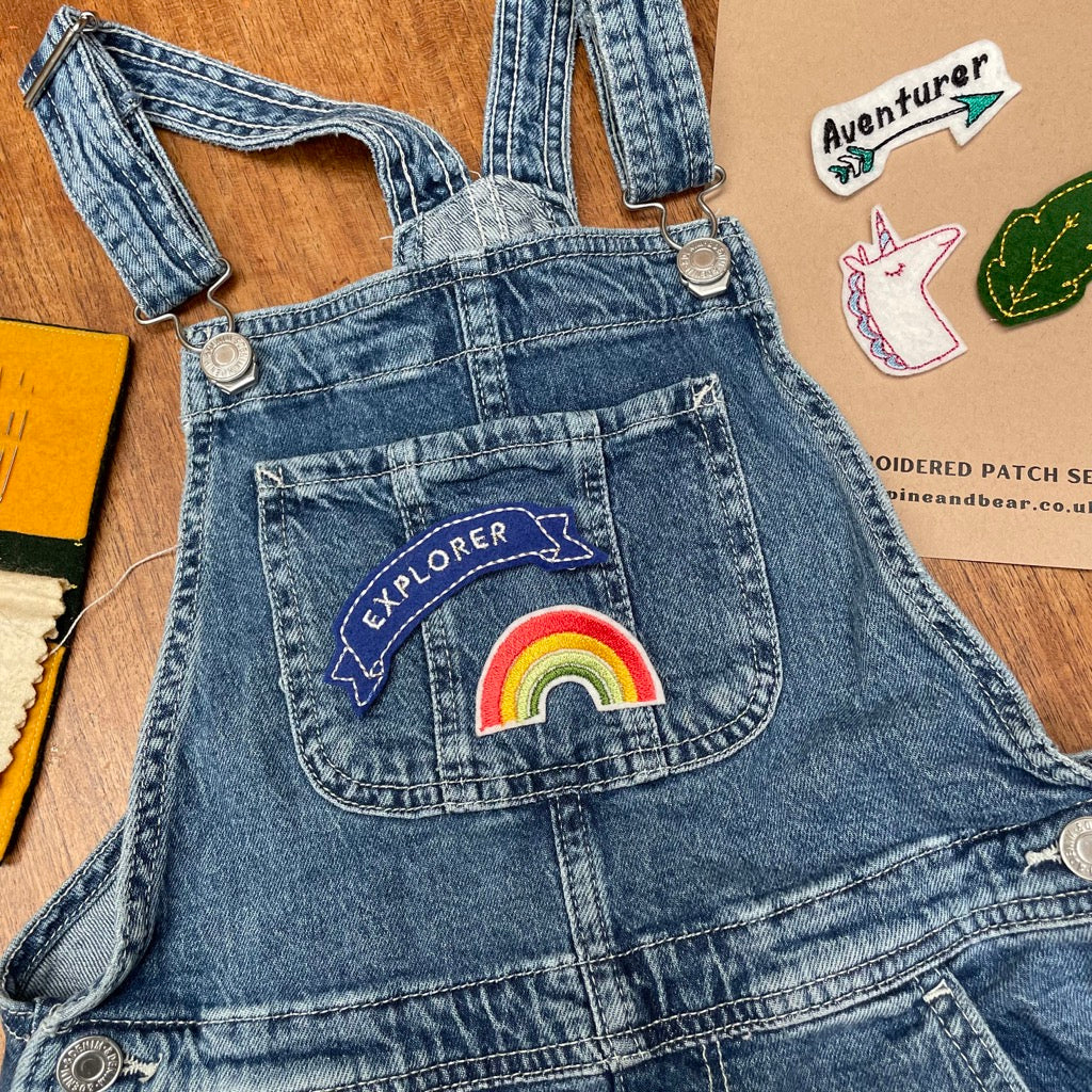 Some denin dungarees with a arainbow and explorer patch on them