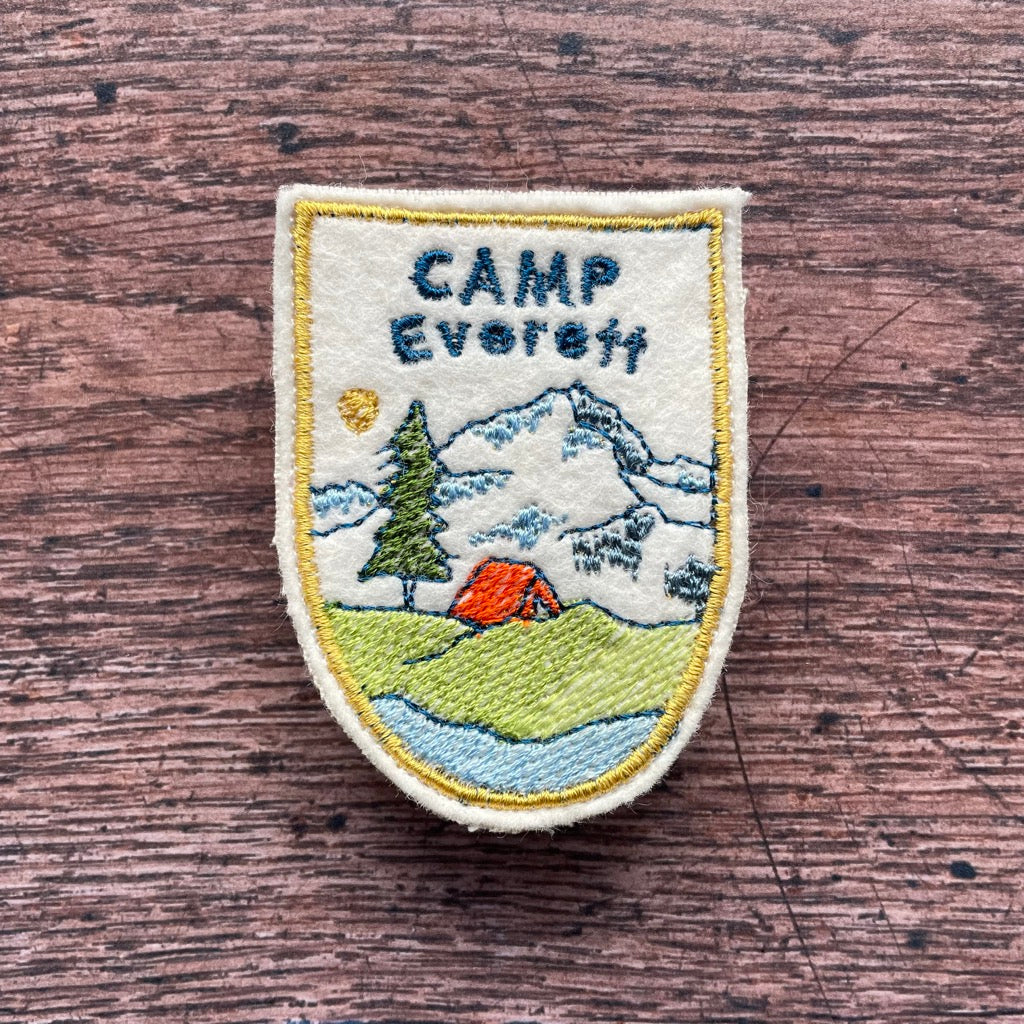 Custom camping patch with tent and mountain design.