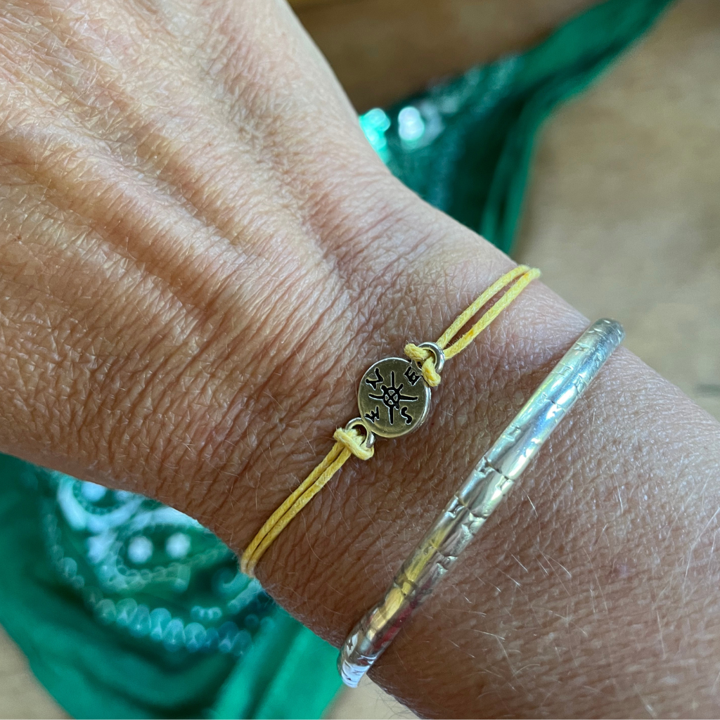 Compass adventure wish bracelets displayed on a ladies wrist.