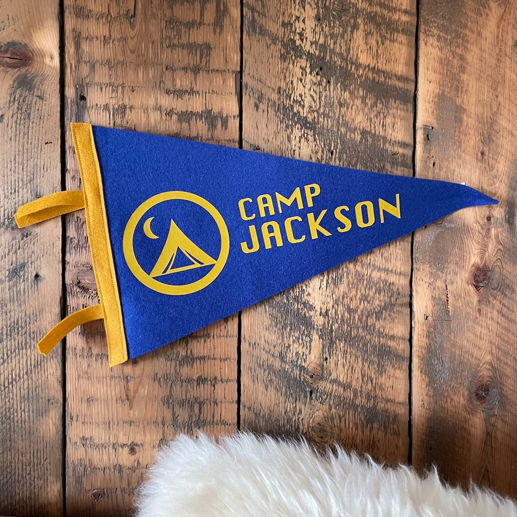 Custom Camp Flag in blue and mustard on a wooden wall