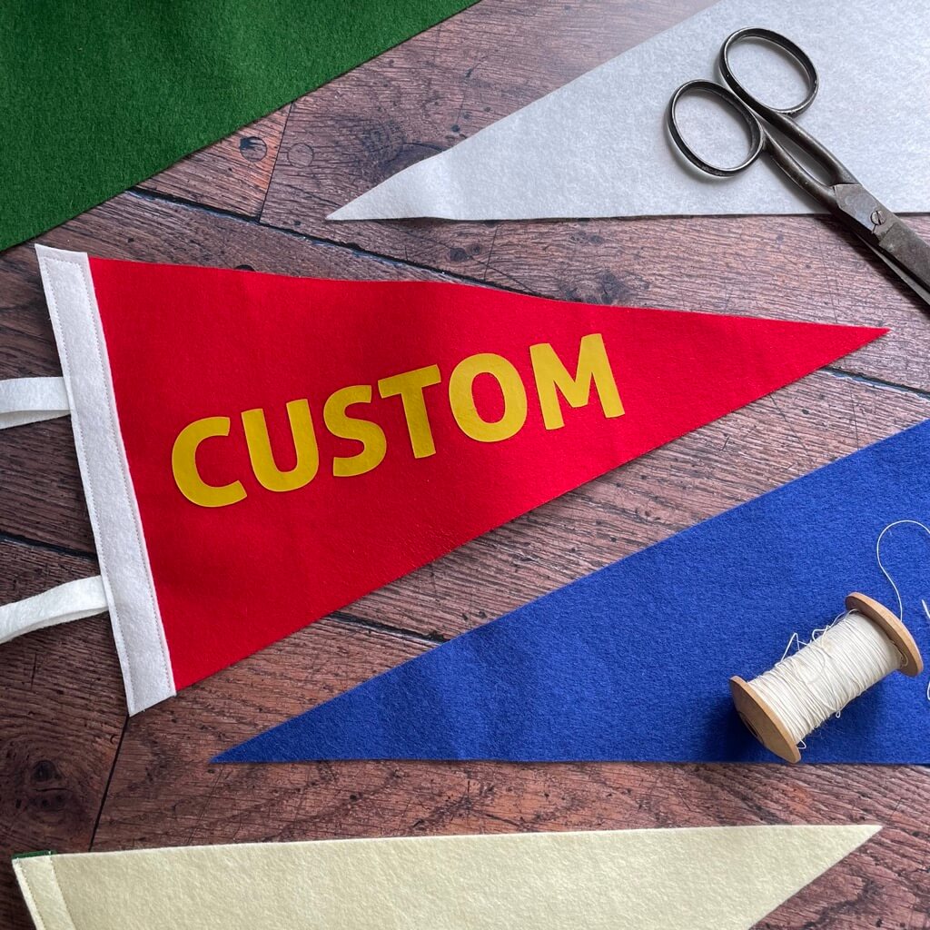 Custom pennant Flag on a wooden table in various olours