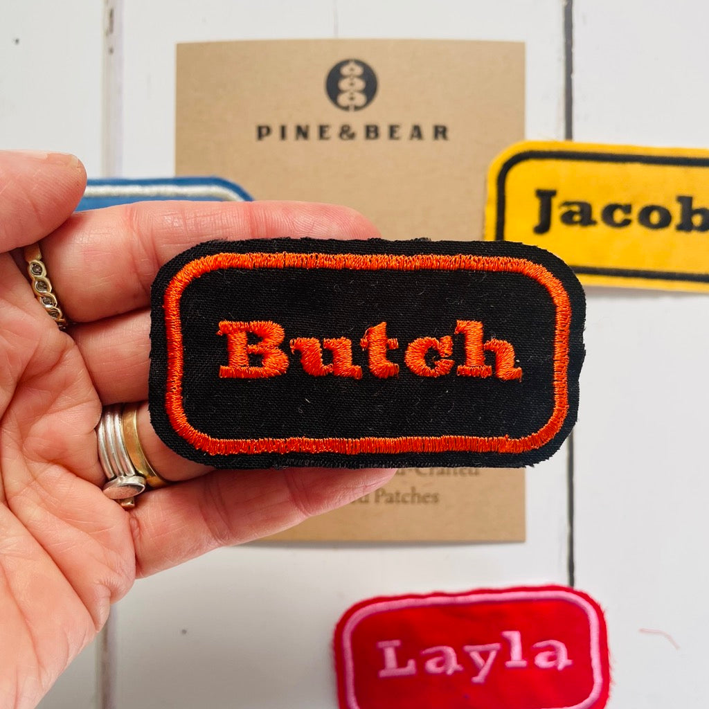custom embroidered name patch in black ad orange