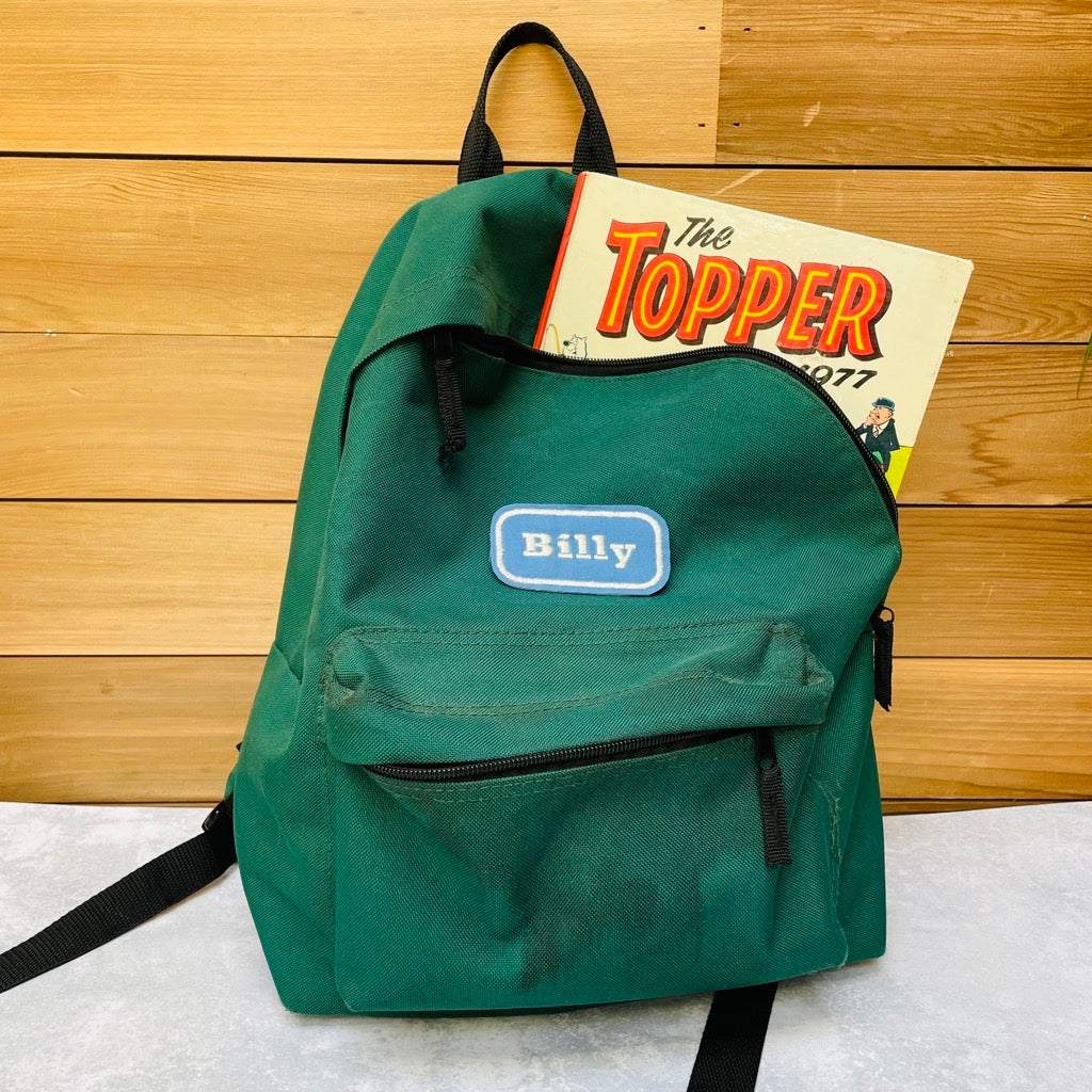 Custom embroidered name patch on a green rucksack.