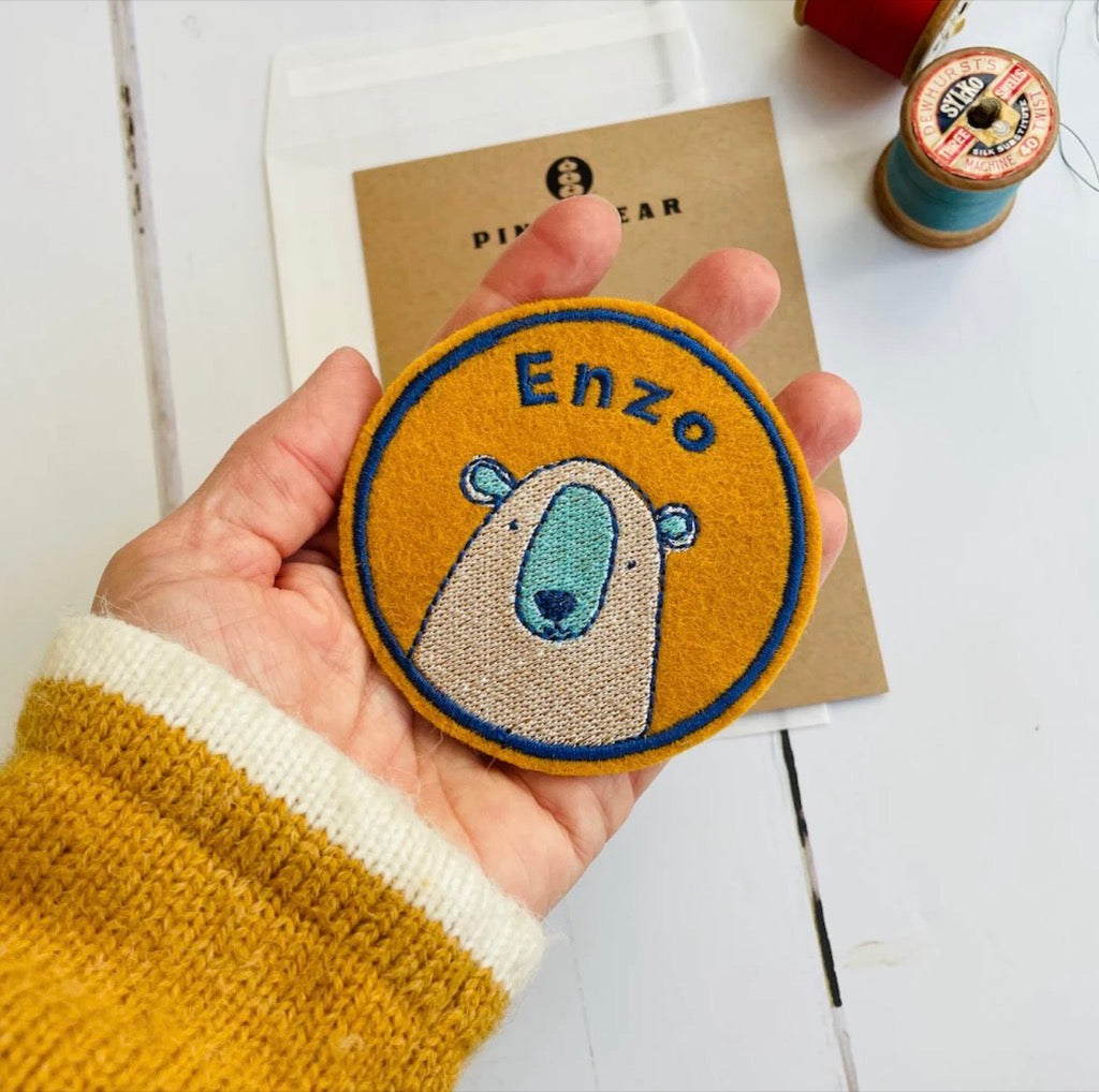Embroidered name patch with a little bear design in mustard