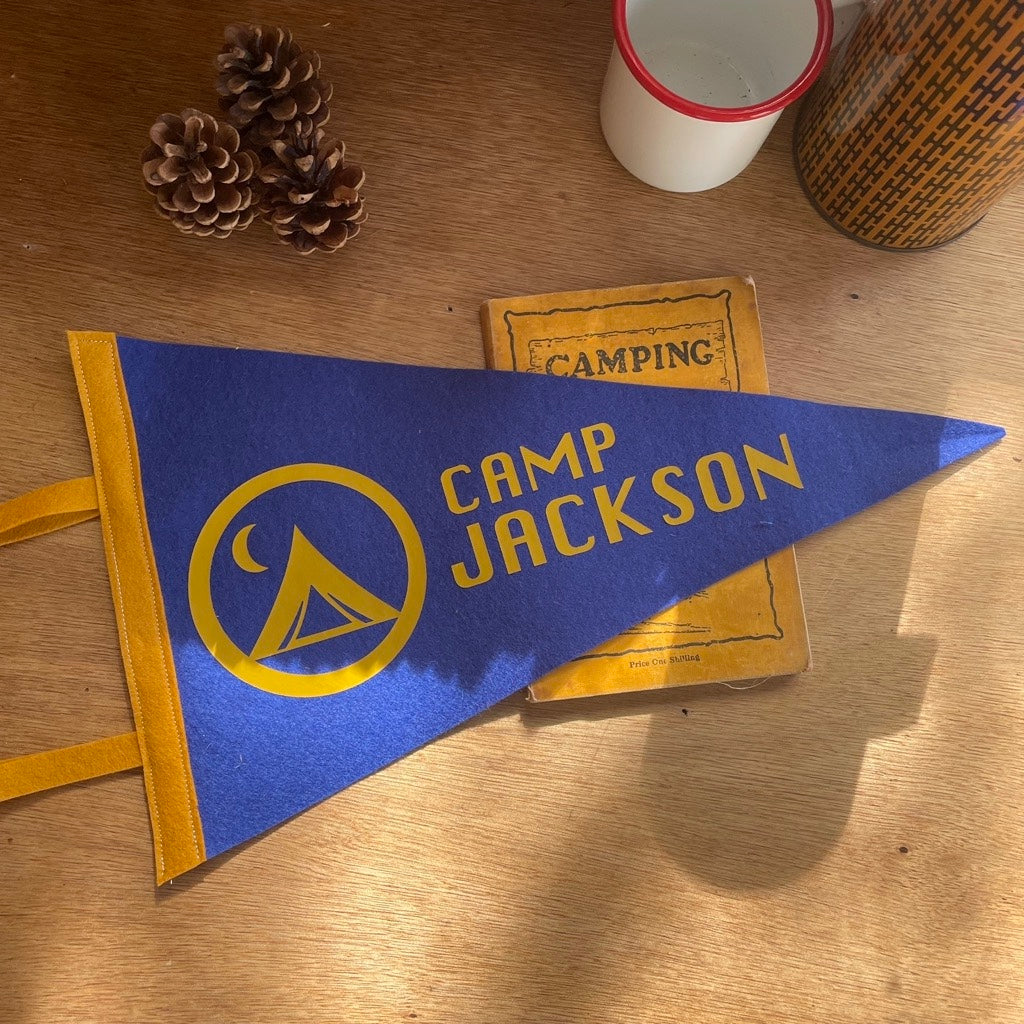 Custom Camp Flag in blue and mustard on a wooden desk