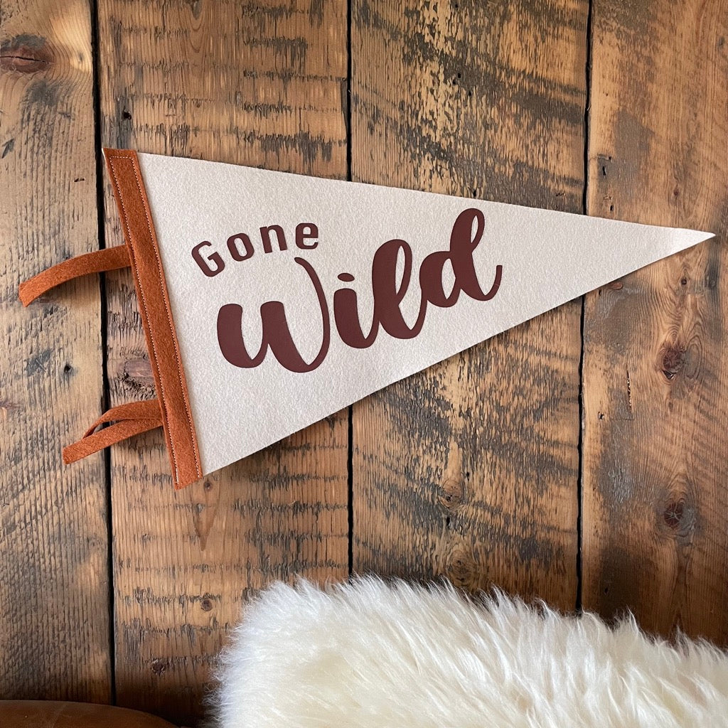 Gone Wild pennant flag in browns on a wooden wall