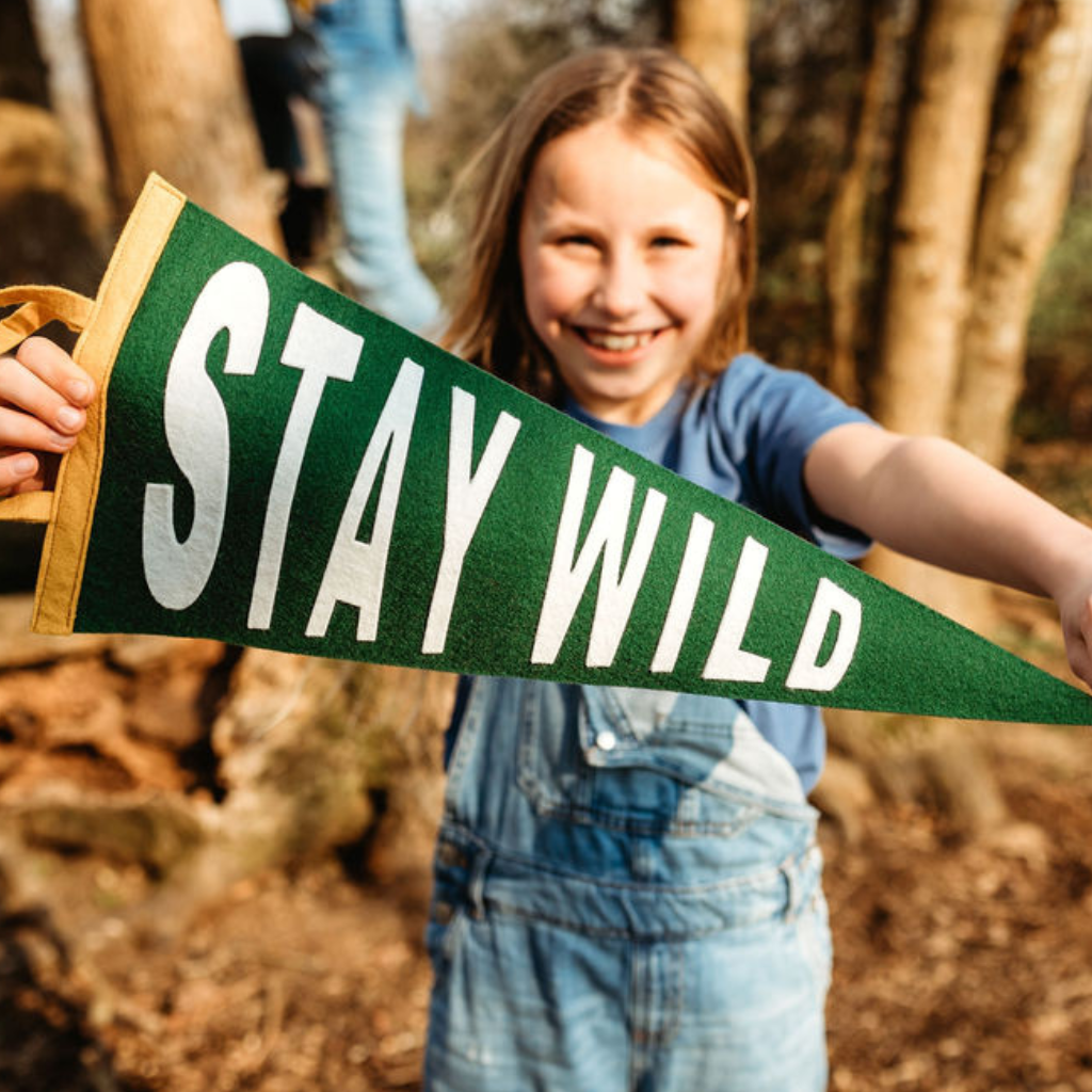 Girl holding a stay wild pennant flag