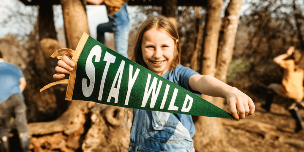 Girl holding a stay wild pennant flag