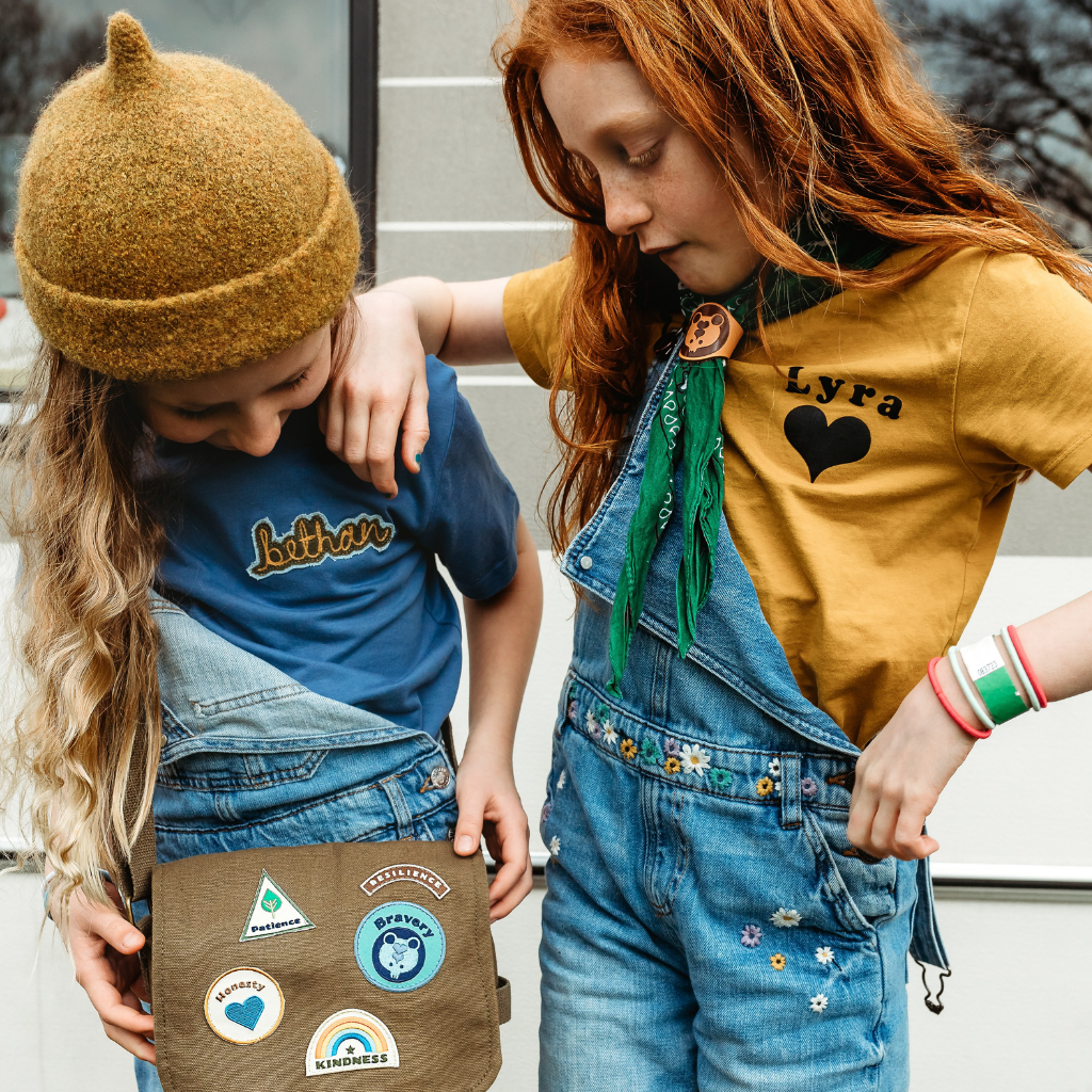2 girls with a bag with merit patches on