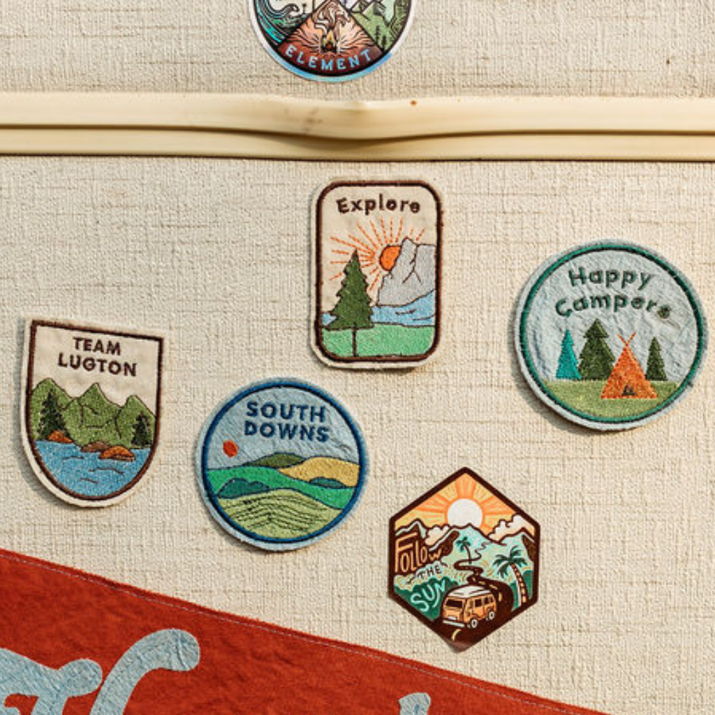 Embroidered adventure patches on door of campervan