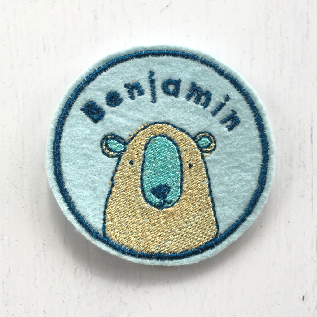 Embroidered name patch with a cute bear design.