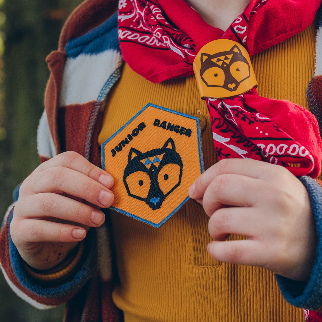 Child holding Junior Ranger embroidered adventure patch.